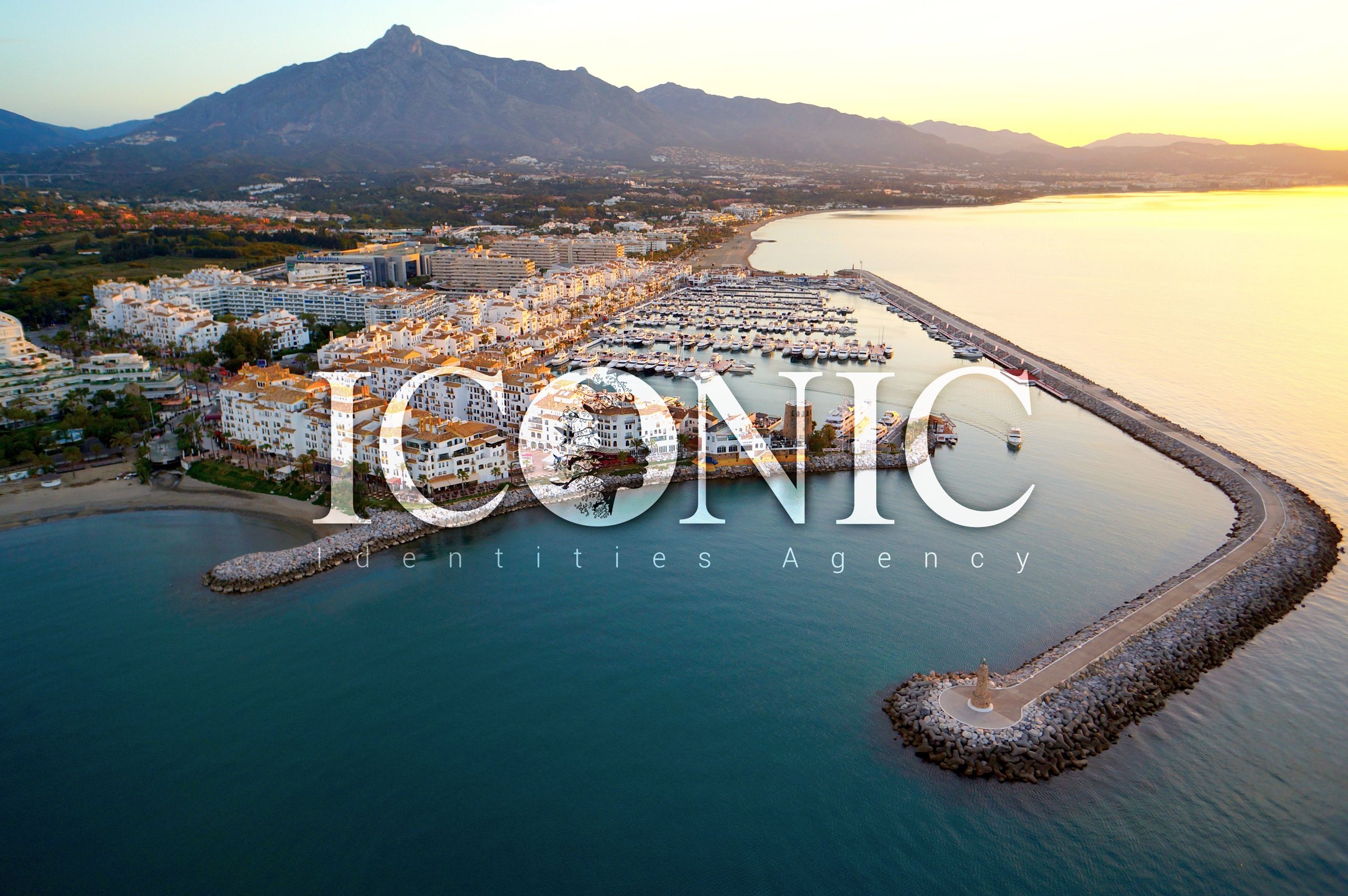Aerial view of the Marbella coastline and marina at sunset, where Iconic Identities is based
