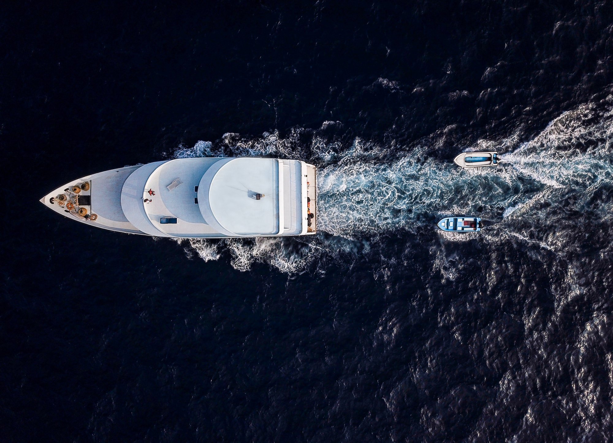 Aerial view of a yacht cutting through deep blue open water